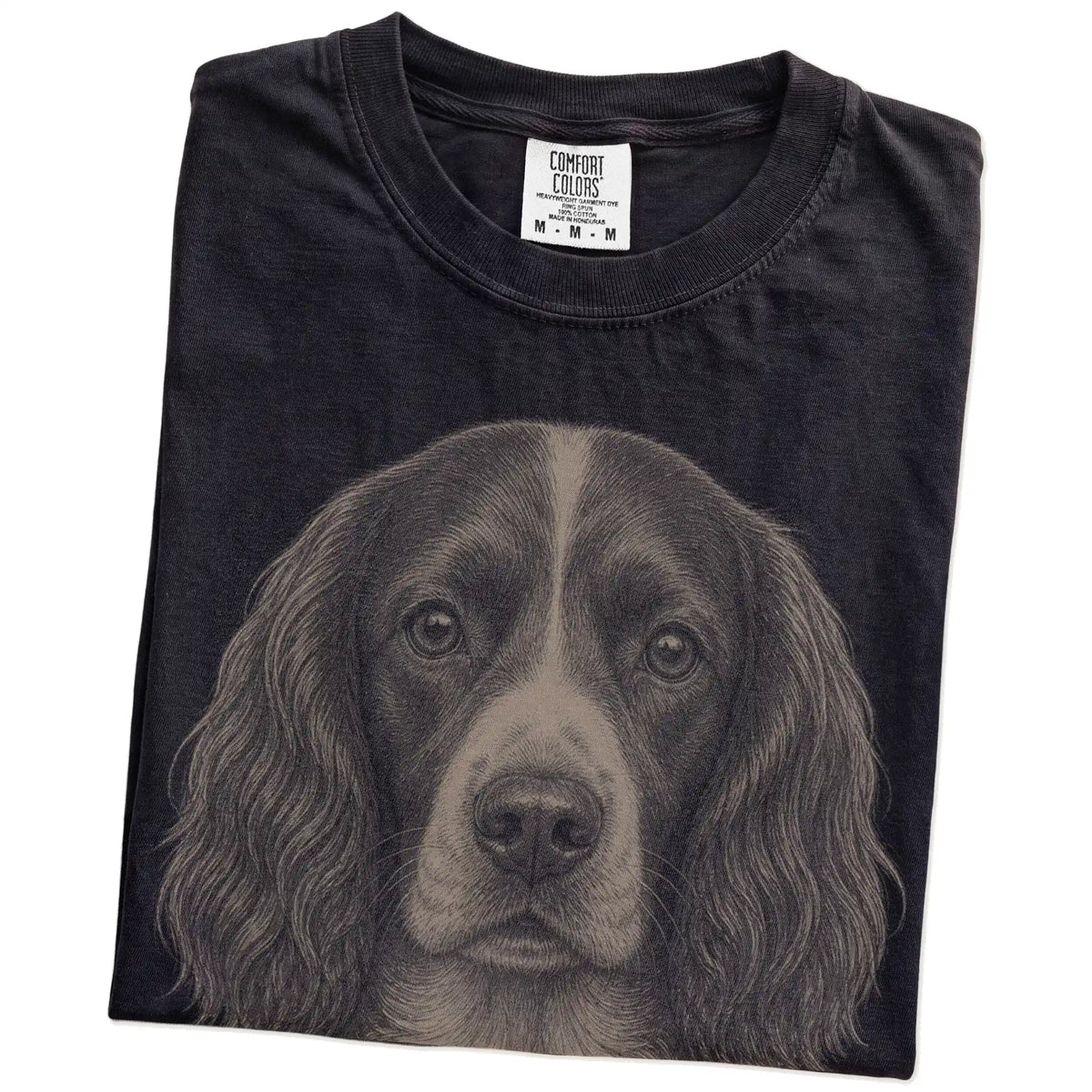 Folded Black Comfort Colors® T-shirt showing a realistic drawing of a Springer Spaniel