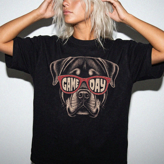 Model wearing a Black Comfort Colors® T-shirt with rottweiler wearing red game day sunglasses