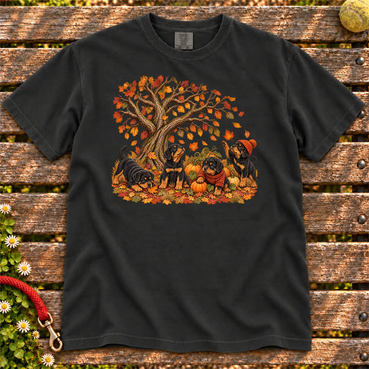 Four Rottweiler puppies with pumpkins beneath an autumn tree on a Black garment-dyed T-shirt