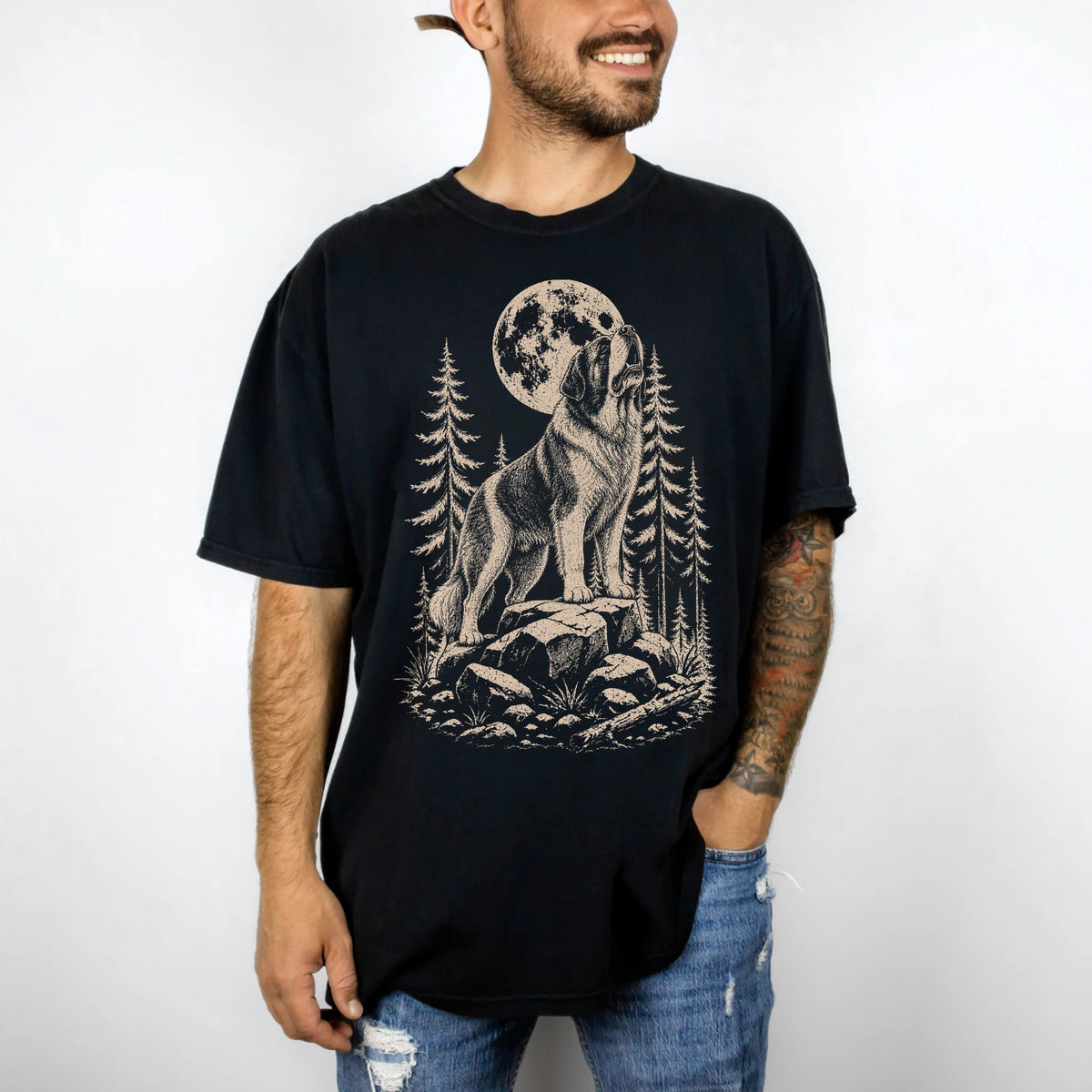 Model wearing a Black Comfort Colors® T-shirt with a Saint Bernard howling beneath the moon and pine trees