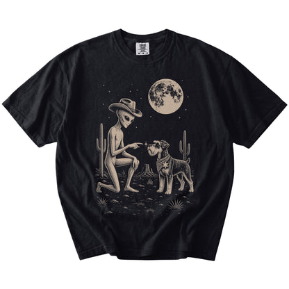 Cowboy alien fist-bumping a Schnauzer beneath the moon on a Black Comfort Colors® T-shirt