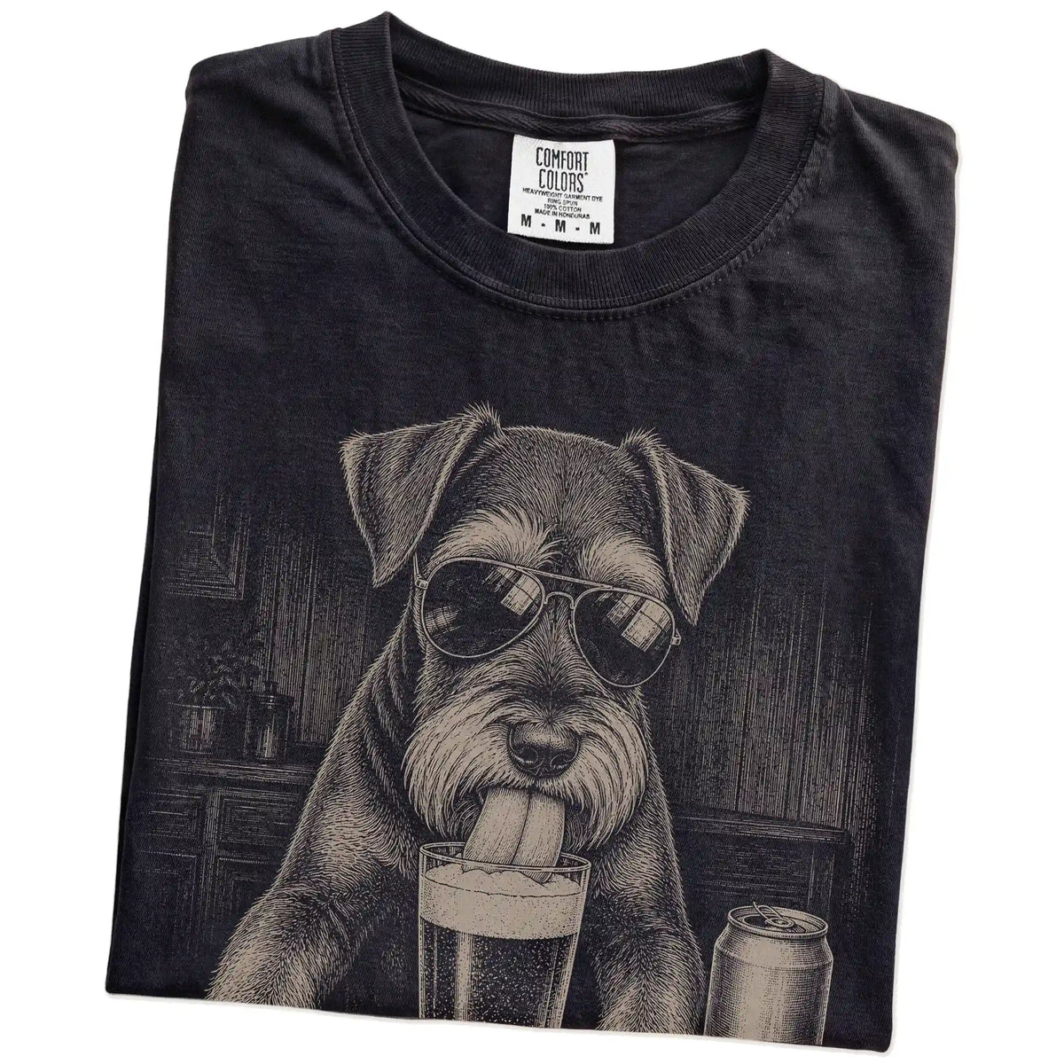 Folded Black Comfort Colors® t-shirt showing Schnauzer sneaking a drink from a pint