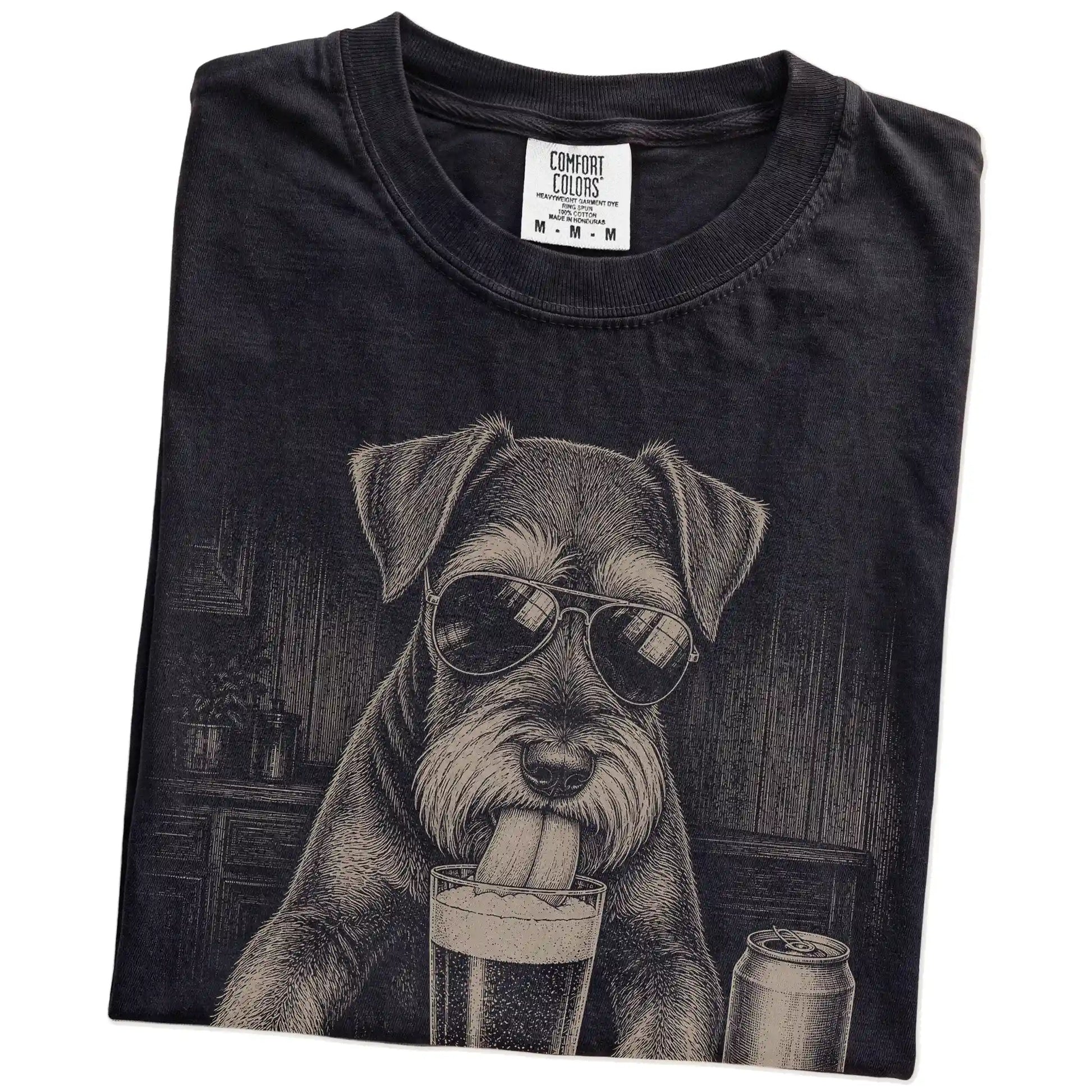 Folded Black Comfort Colors® t-shirt showing Schnauzer sneaking a drink from a pint