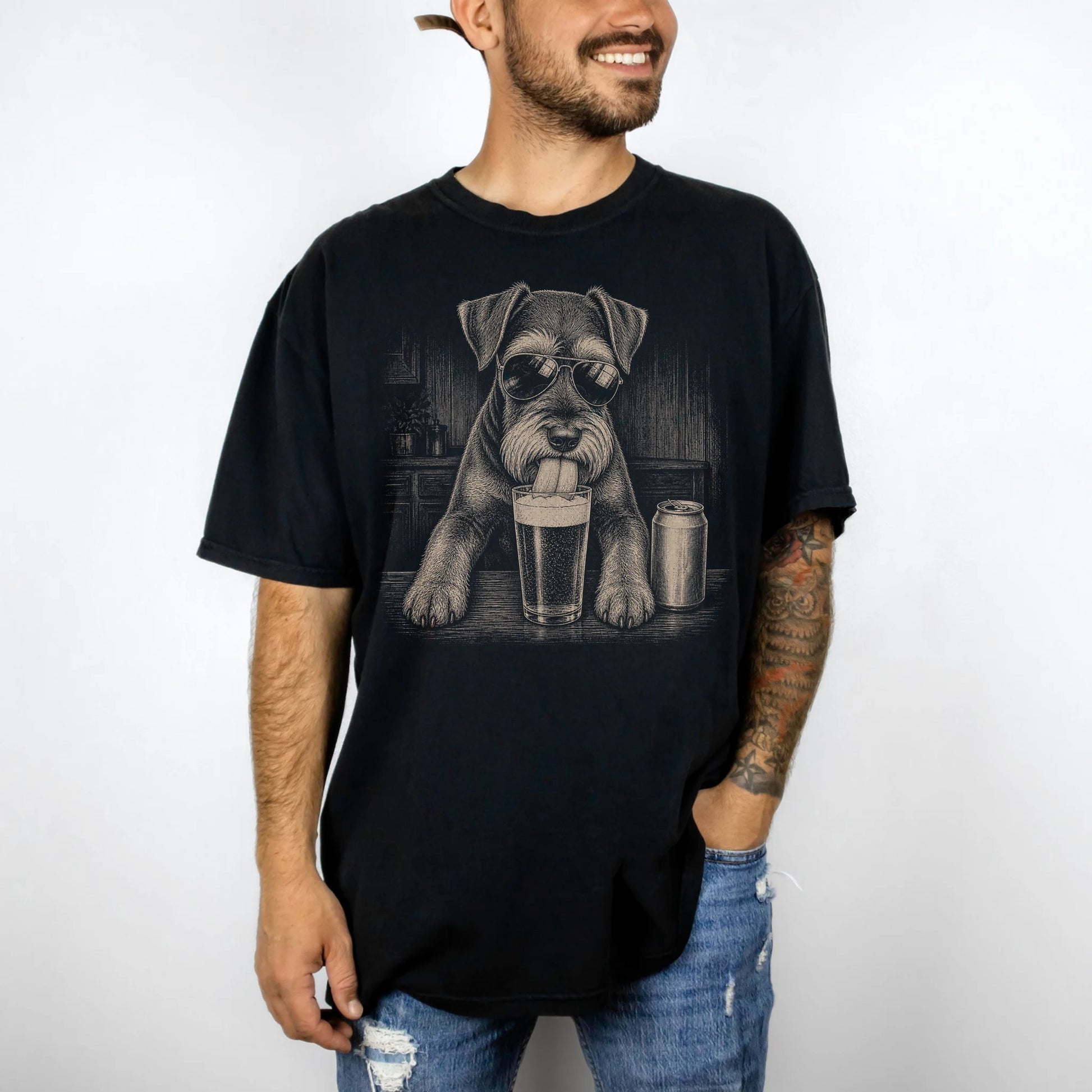 Model wearing a Black Comfort Colors® t-shirt with Schnauzer sneaking a drink from a pint