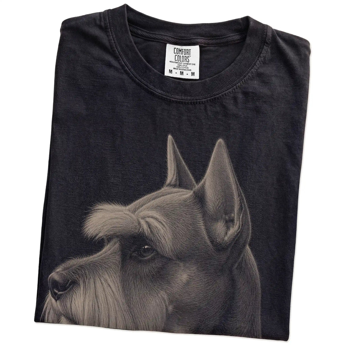 Folded Black Comfort Colors® T-shirt showing a detailed photographic portrait of a Schnauzer