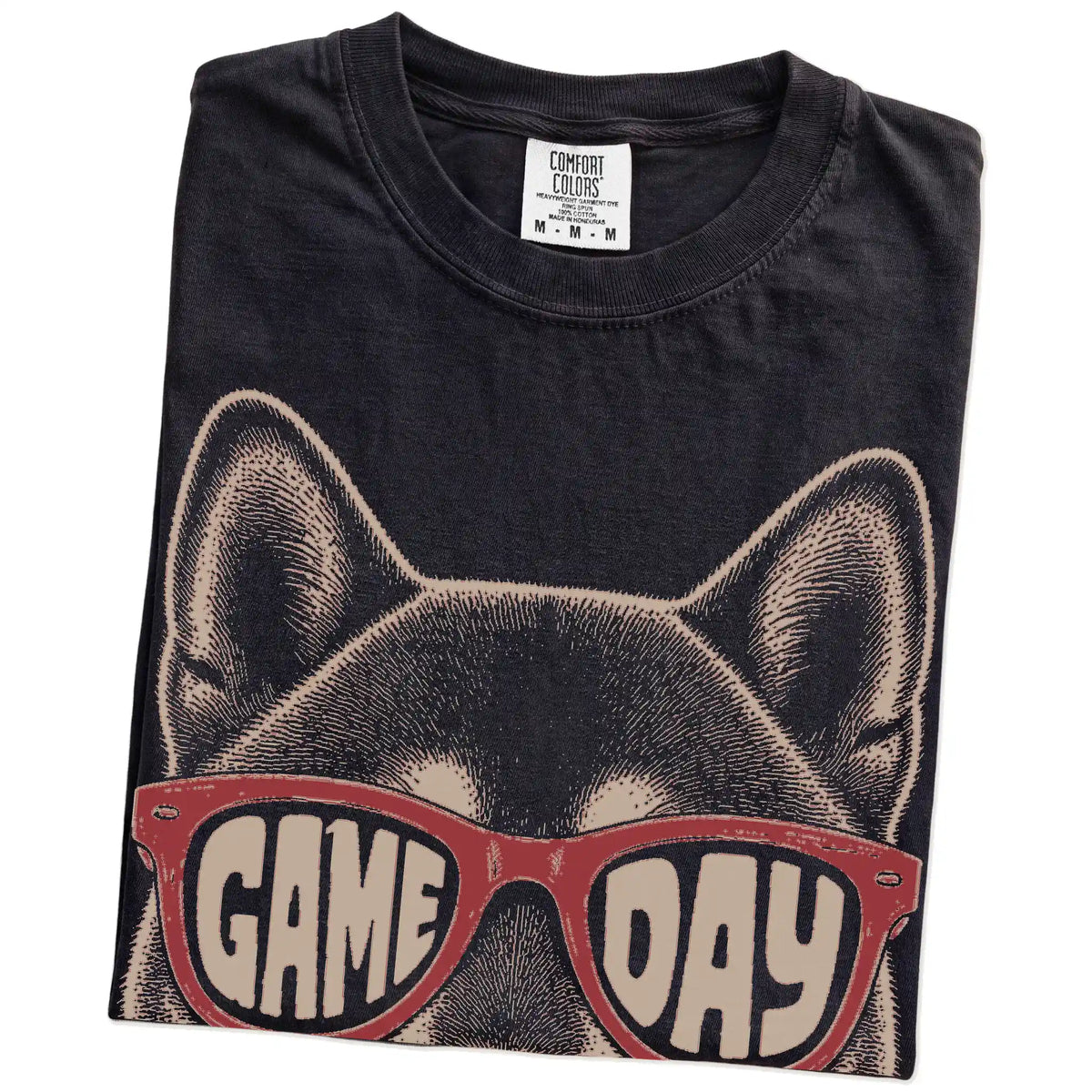 Folded Black Comfort Colors® T-shirt showing shiba inu wearing red game day sunglasses