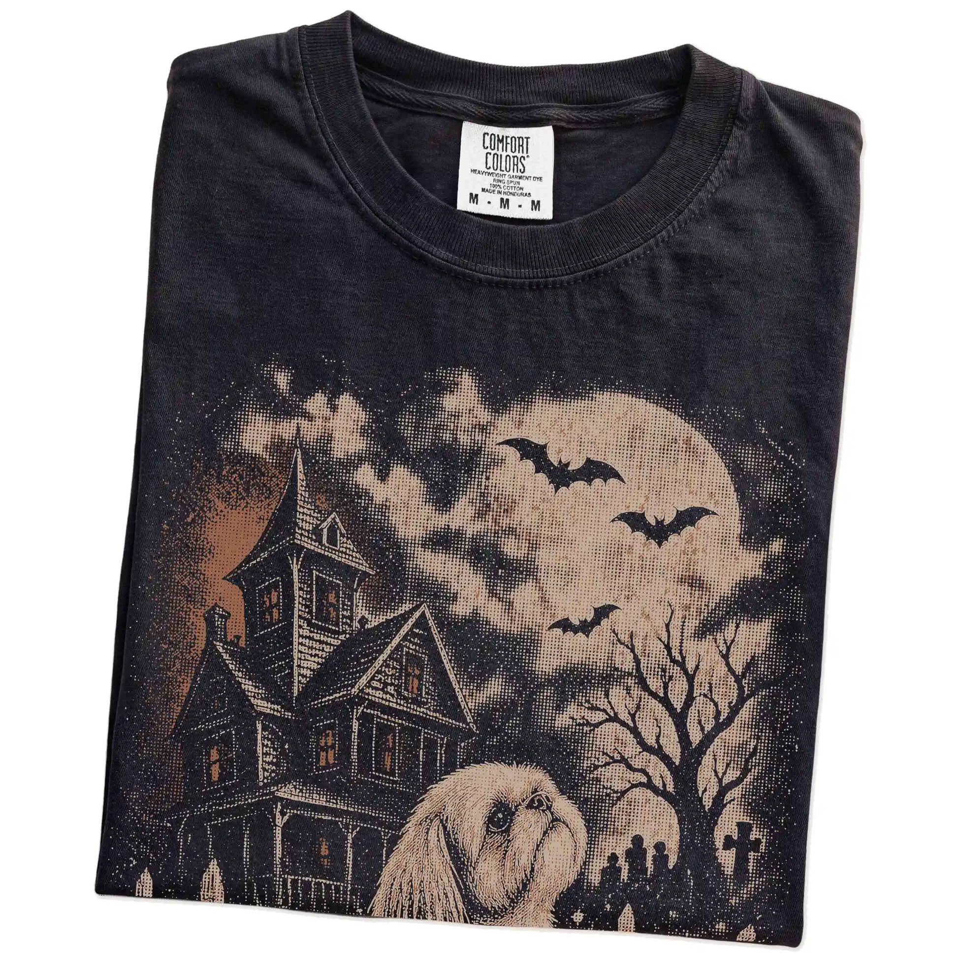 Folded Black Comfort Colors® T-shirt showing Shih Tzu in a vintage haunted-house scene