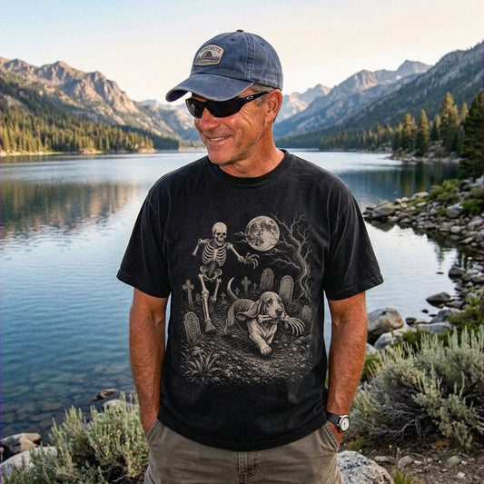 Model wearing a Black Comfort Colors® T-shirt showing Basset Hound running through a moonlit graveyard with a chasing skeleto