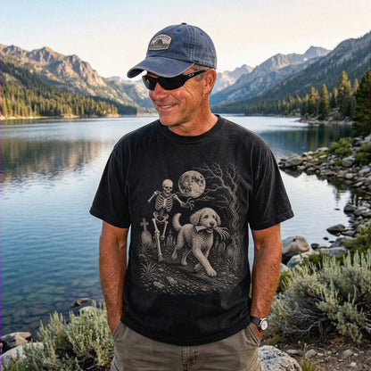Model wearing a Black Comfort Colors® T-shirt showing Labradoodle running through a moonlit graveyard with a chasing skeleton