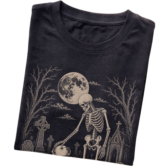 Folded Black T-shirt with a skeleton petting an American Bulldog in a graveyard