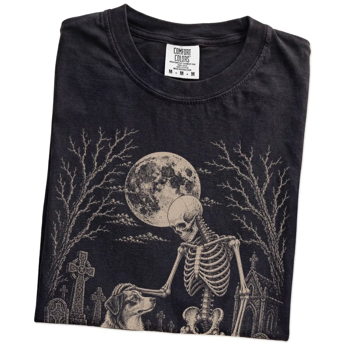 Folded Black Comfort Colors® T-shirt showing Australian Shepherd sharing a quiet cemetery moment with a friendly skeleton