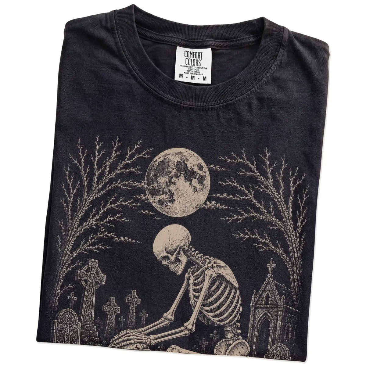 Folded Black Comfort Colors® T-shirt showing Bulldog sharing a quiet cemetery moment with a friendly skeleton