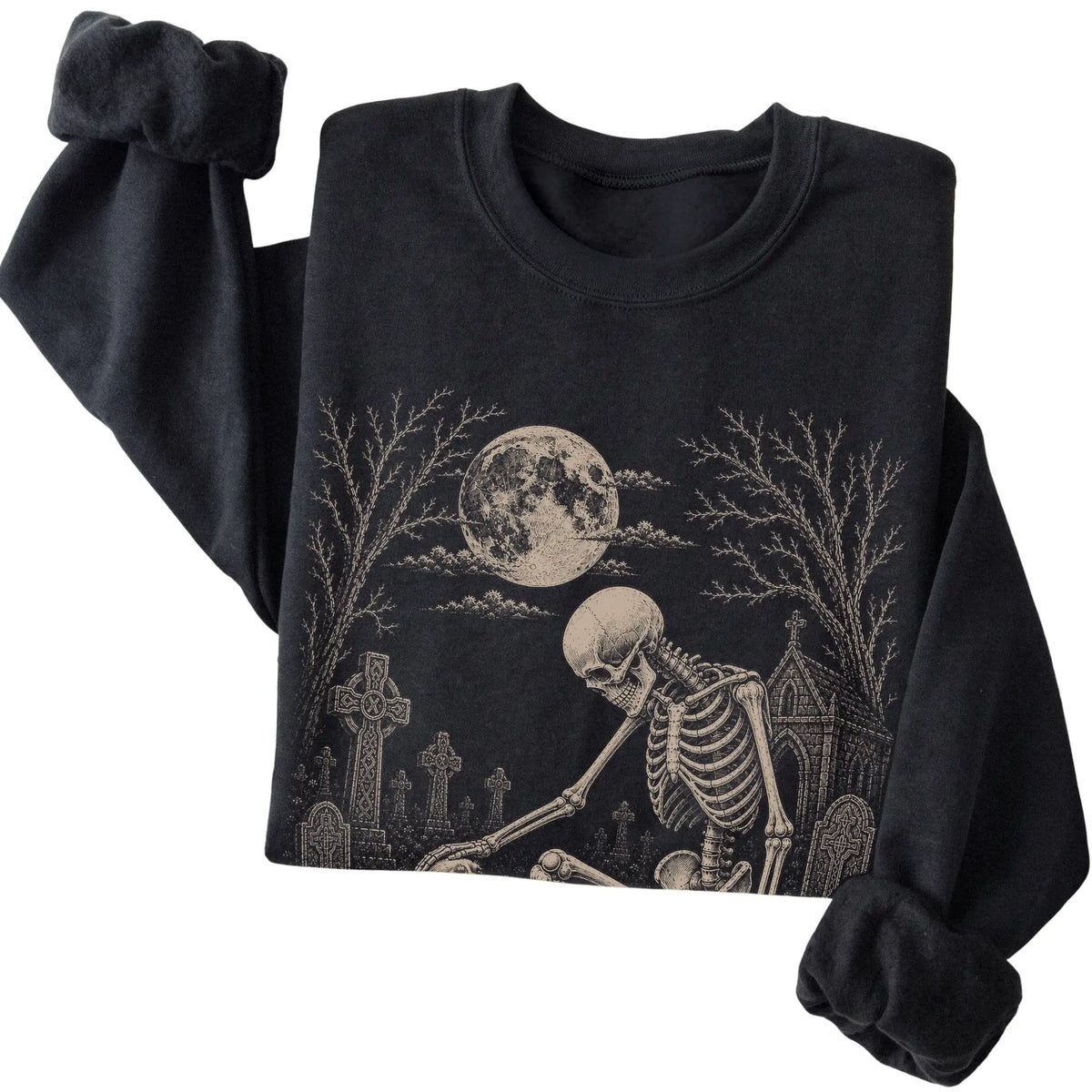 Folded Black sweatshirt with a skeleton petting a Cavalier in a graveyard