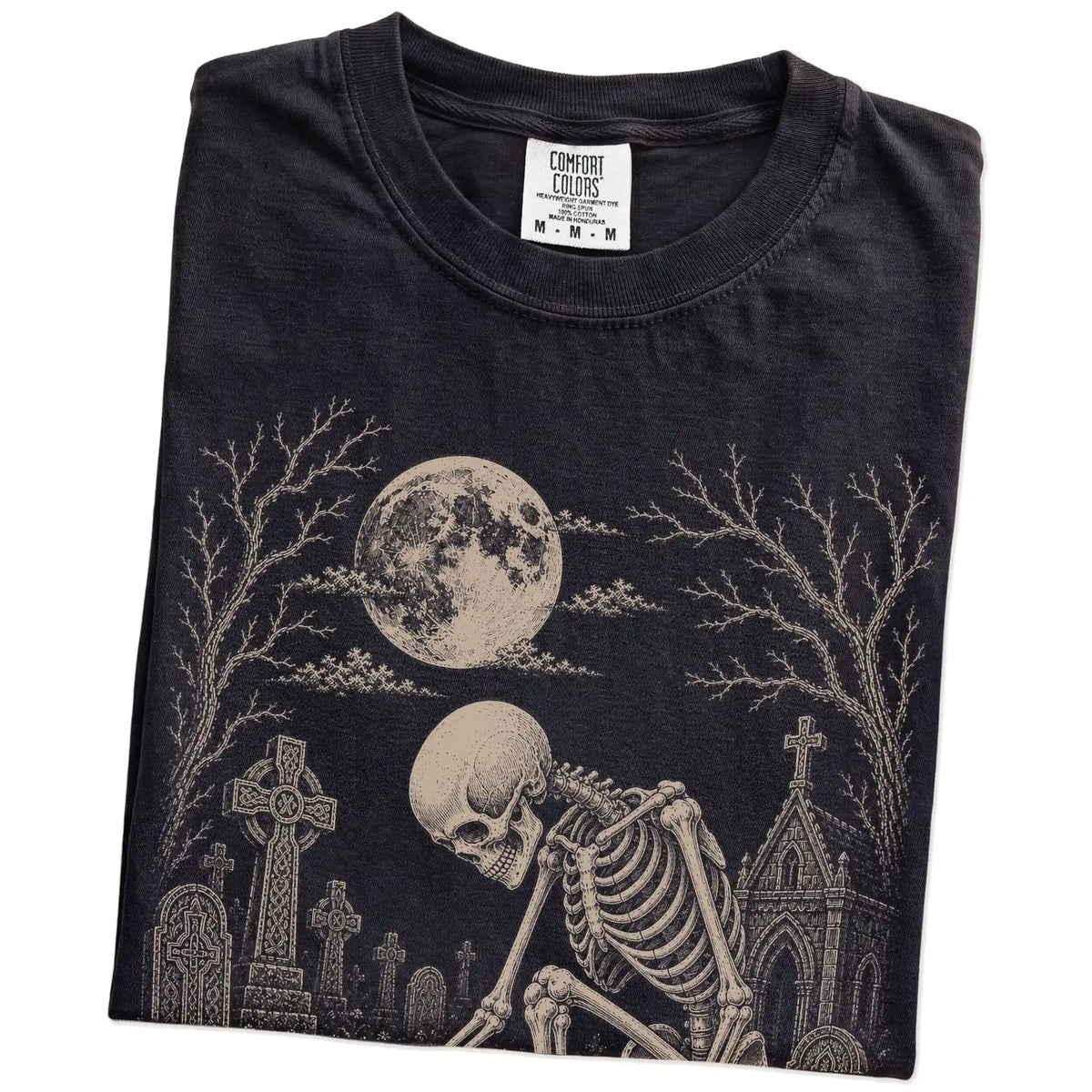 Folded Black Comfort Colors® T-shirt showing Chihuahua sharing a quiet cemetery moment with a friendly skeleton