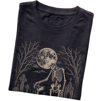 Folded Black T-shirt with a skeleton petting a Doberman in a graveyard
