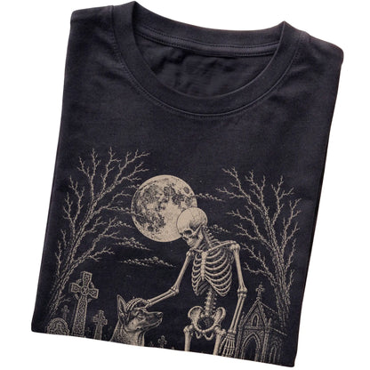 Folded Black T-shirt with a skeleton petting a German Shepherd in a graveyard