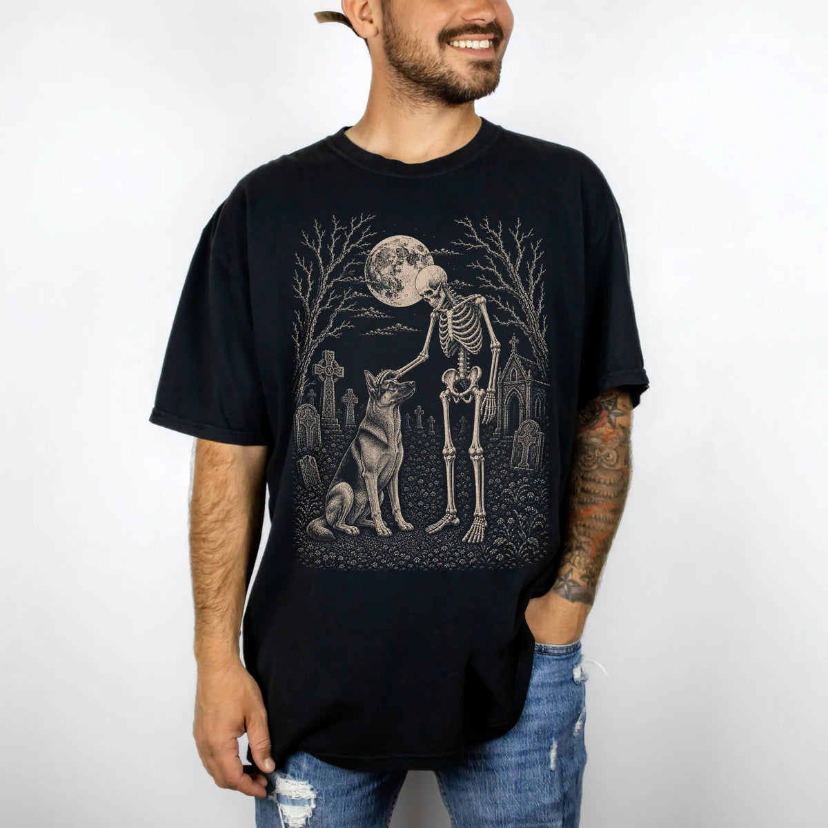 Model wearing a Black Comfort Colors® T-shirt showing German Shepherd sharing a quiet cemetery moment with a friendly skeleto