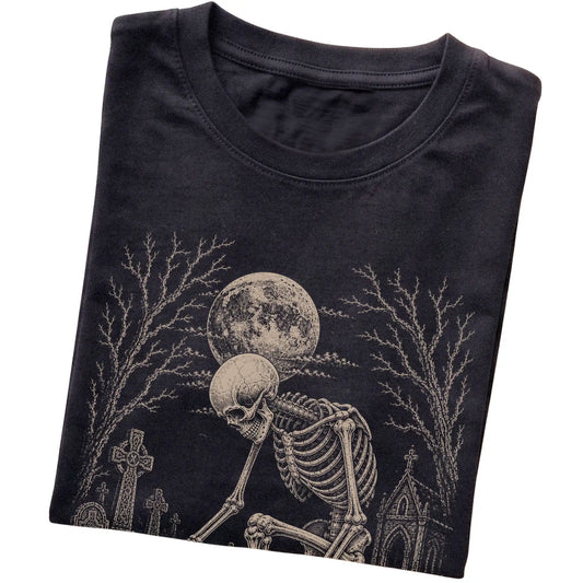 Folded Black T-shirt with a skeleton petting a Havanese in a graveyard