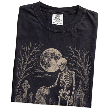 Folded Black Comfort Colors® T-shirt showing Irish Setter sharing a quiet cemetery moment with a friendly skeleton