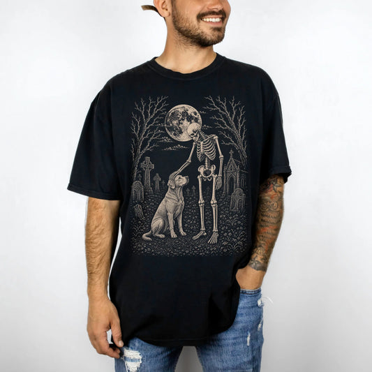 Model wearing a Black Comfort Colors® T-shirt showing Labrador Retriever sharing a quiet cemetery moment with a friendly skel