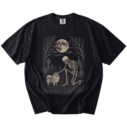 Pomeranian sharing a quiet cemetery moment with a friendly skeleton on a Black Comfort Colors® T-shirt