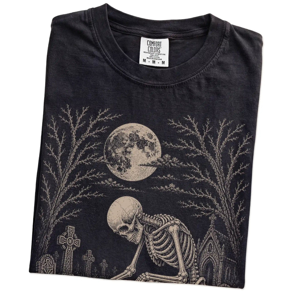 Folded Black Comfort Colors® T-shirt showing Pug sharing a quiet cemetery moment with a friendly skeleton