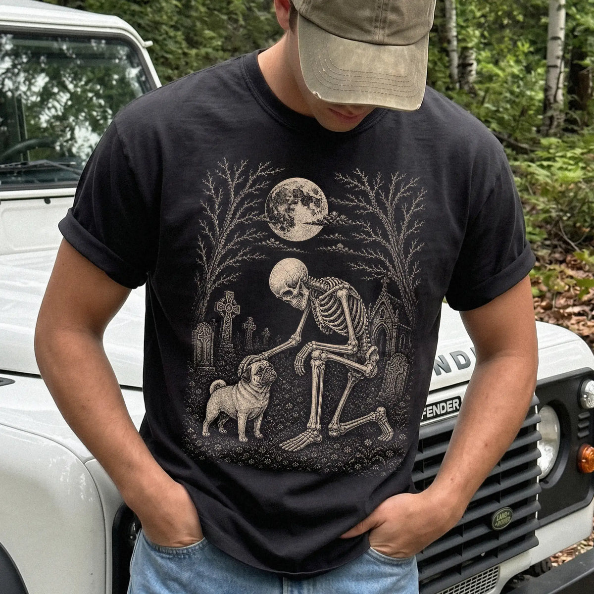Model wearing a Black Comfort Colors® T-shirt showing Pug sharing a quiet cemetery moment with a friendly skeleton