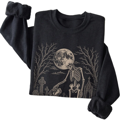 Folded Black sweatshirt with a skeleton petting a Rottweiler in a graveyard