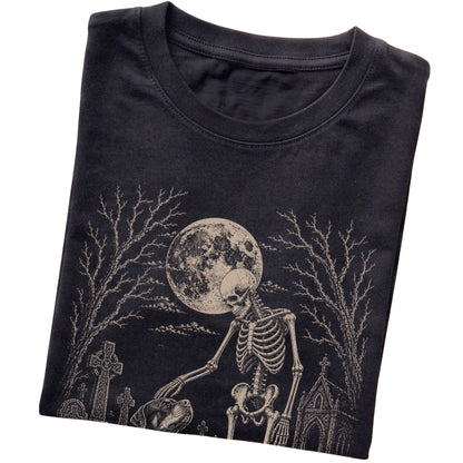 Folded Black T-shirt with a skeleton petting a Rottweiler in a graveyard