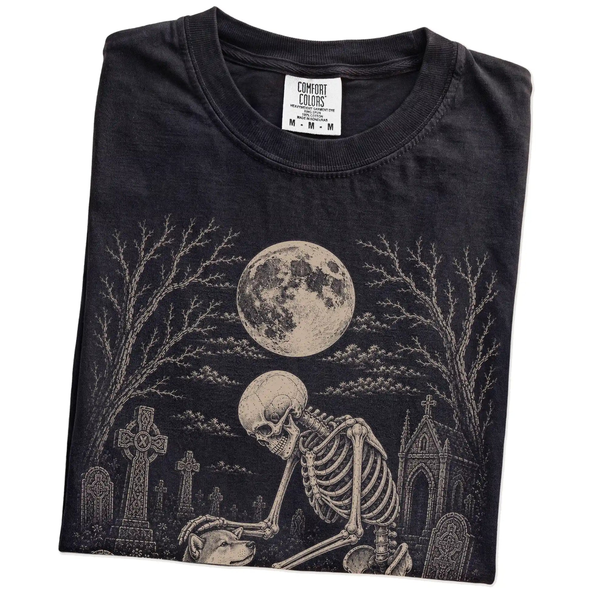 Folded Black Comfort Colors® T-shirt showing Shiba Inu sharing a quiet cemetery moment with a friendly skeleton