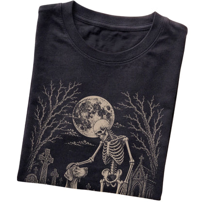 Folded Black T-shirt with a skeleton petting a Weimaraner in a graveyard