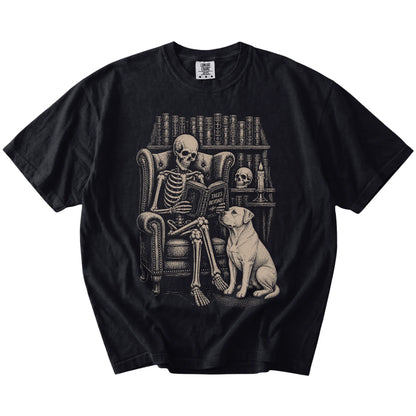 Skeleton reading in a library beside a American Bulldog on a Black Comfort Colors® T-shirt
