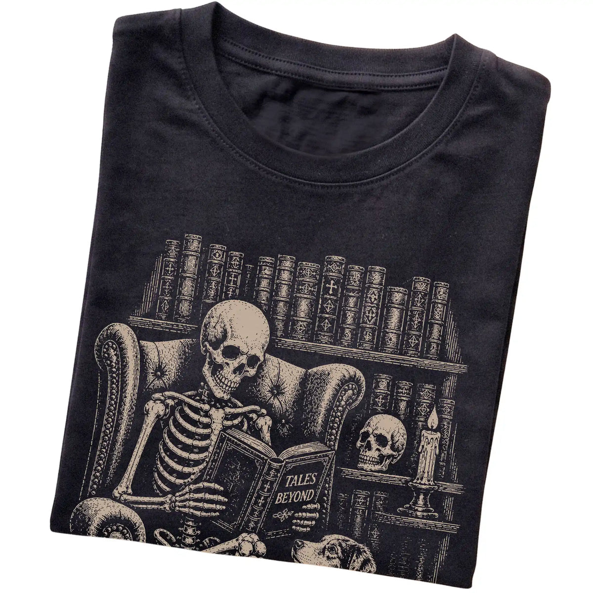 Folded Black T-shirt with a skeleton reading Tales Beyond to an Australian Shepherd
