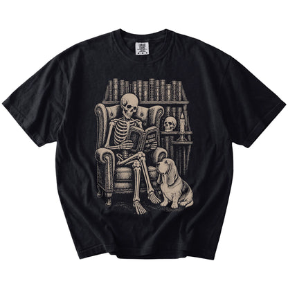 Skeleton reading in a library beside a Basset Hound on a Black Comfort Colors® T-shirt