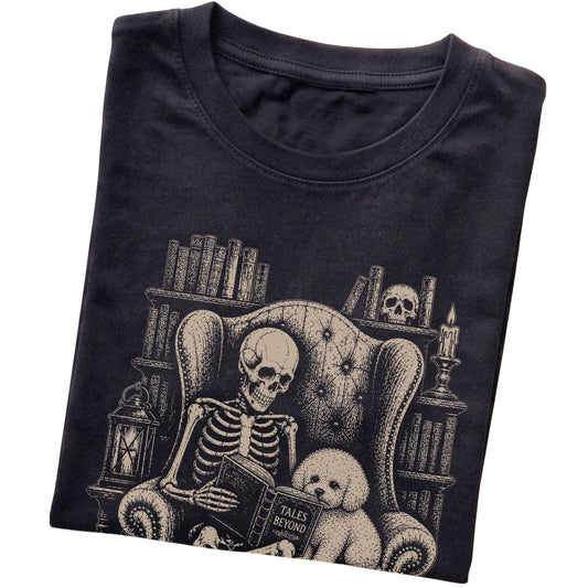 Folded Black T-shirt with a skeleton reading Tales Beyond to a Bichon Frise