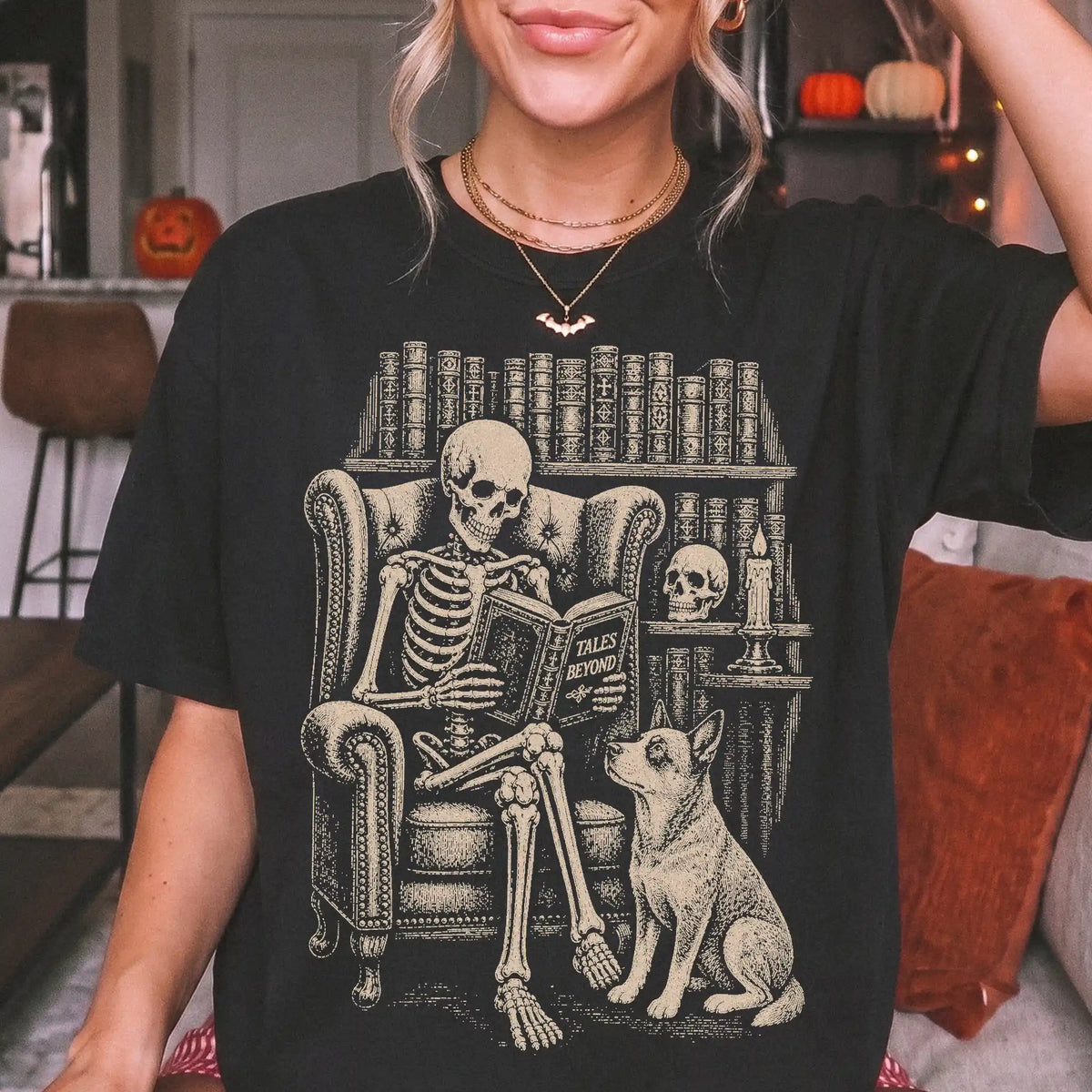 Model wearing a Black Comfort Colors® T-shirt showing skeleton reading in a library beside a Blue Heeler