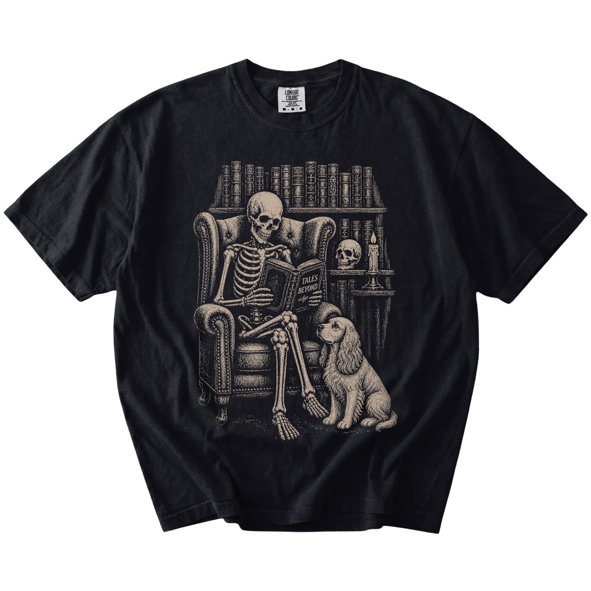 Skeleton reading in a library beside a Cocker Spaniel on a Black Comfort Colors® T-shirt