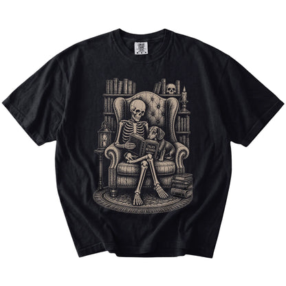 Skeleton reading in a library beside a Dachshund on a Black Comfort Colors® T-shirt