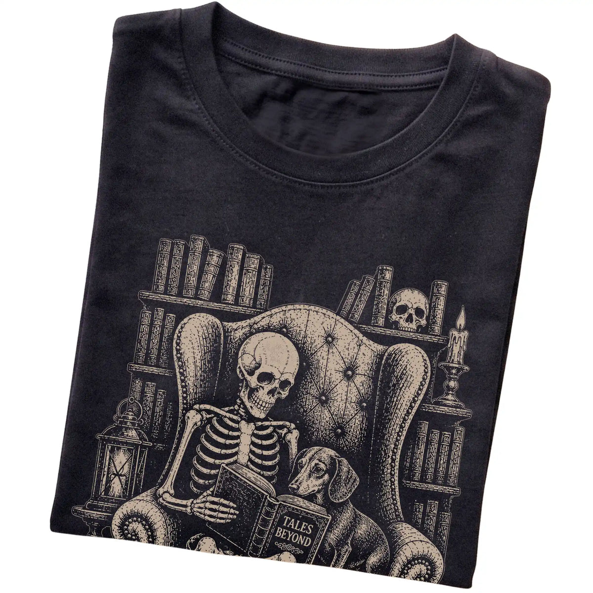 Folded Black T-shirt with a skeleton reading Tales Beyond to a Dachshund