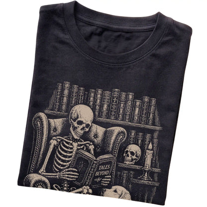 Folded Black T-shirt with a skeleton reading Tales Beyond to a Golden Retriever