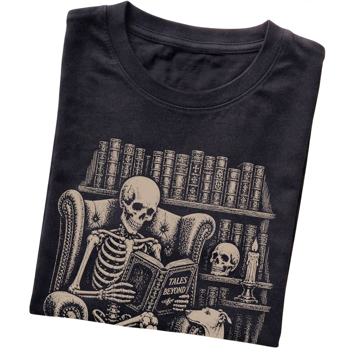 Folded Black T-shirt with a skeleton reading Tales Beyond to a Greyhound