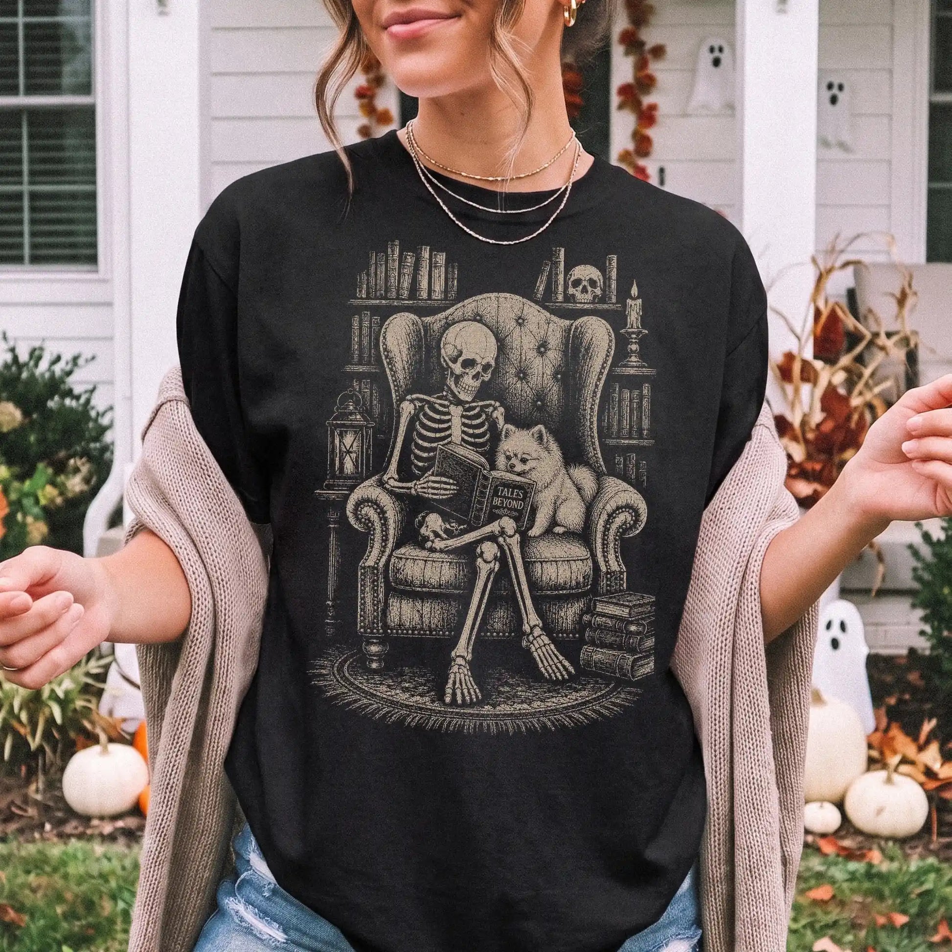 Model wearing a Black Comfort Colors® T-shirt showing skeleton reading in a library beside a Pomeranian