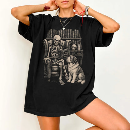Model wearing a Black Comfort Colors® T-shirt showing skeleton reading in a library beside a Saint Bernard