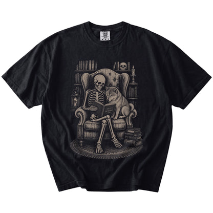 Skeleton reading in a library beside a Shiba Inu on a Black Comfort Colors® T-shirt
