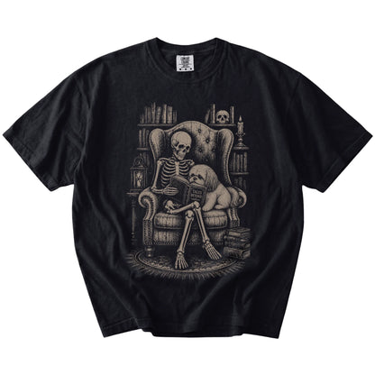 Skeleton reading in a library beside a Shih Tzu on a Black Comfort Colors® T-shirt