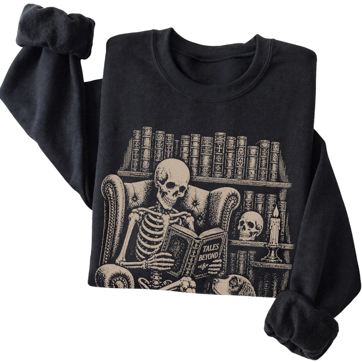 Folded Black sweatshirt with a skeleton reading Tales Beyond to a Springer Spaniel