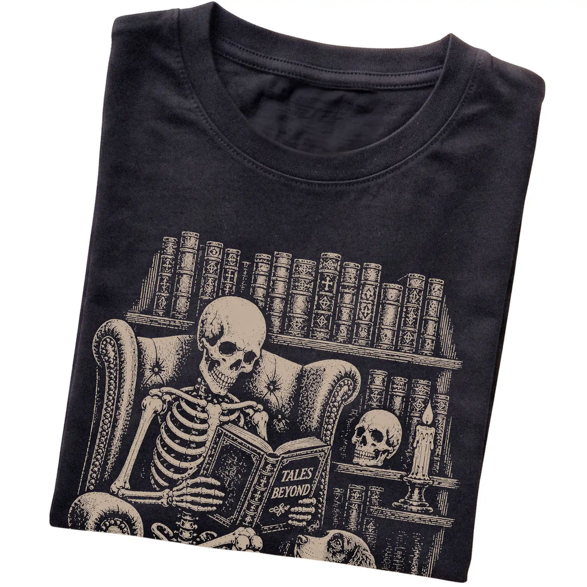 Folded Black T-shirt with a skeleton reading Tales Beyond to a Springer Spaniel