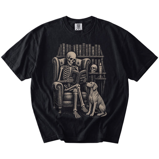Skeleton reading in a library beside a Weimaraner on a Black Comfort Colors® T-shirt