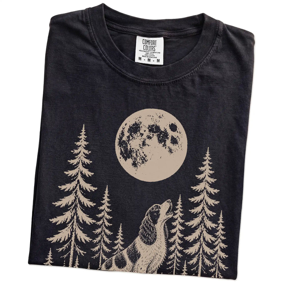 Folded Black Comfort Colors® T-shirt showing a Springer Spaniel howling beneath the moon and pine trees