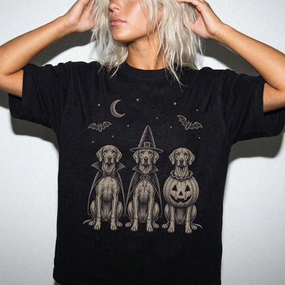 Model wearing a Black Comfort Colors® T-shirt showing three Vizsla dogs dressed for Halloween beneath bats and a crescent moo